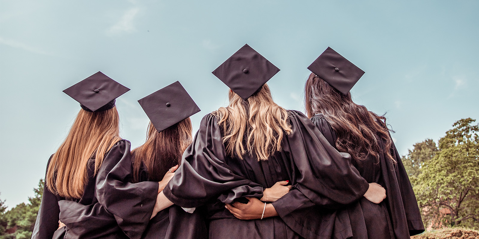 four women in graduation caps and gowns